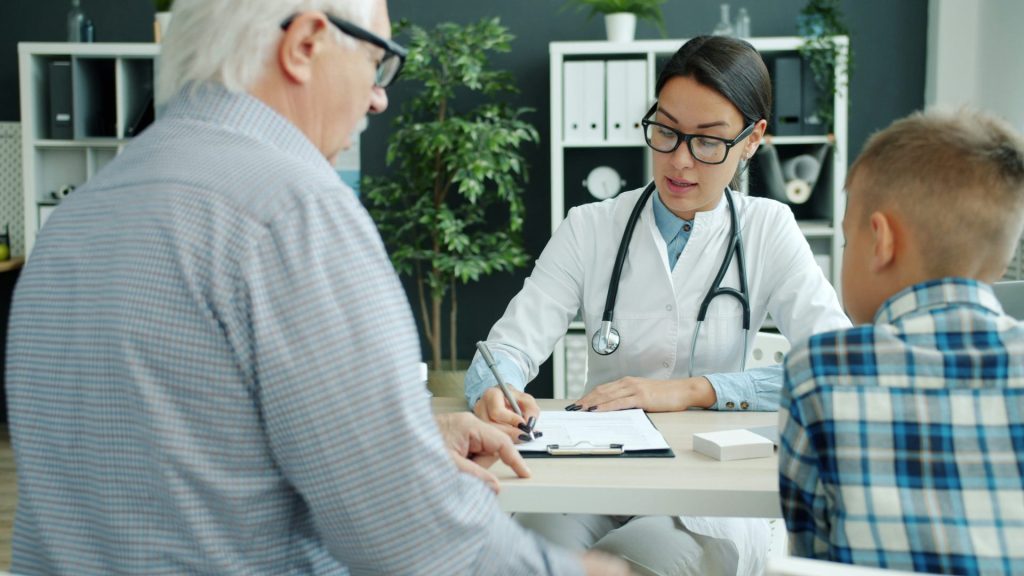 Doctor consulting with elderly man and child.